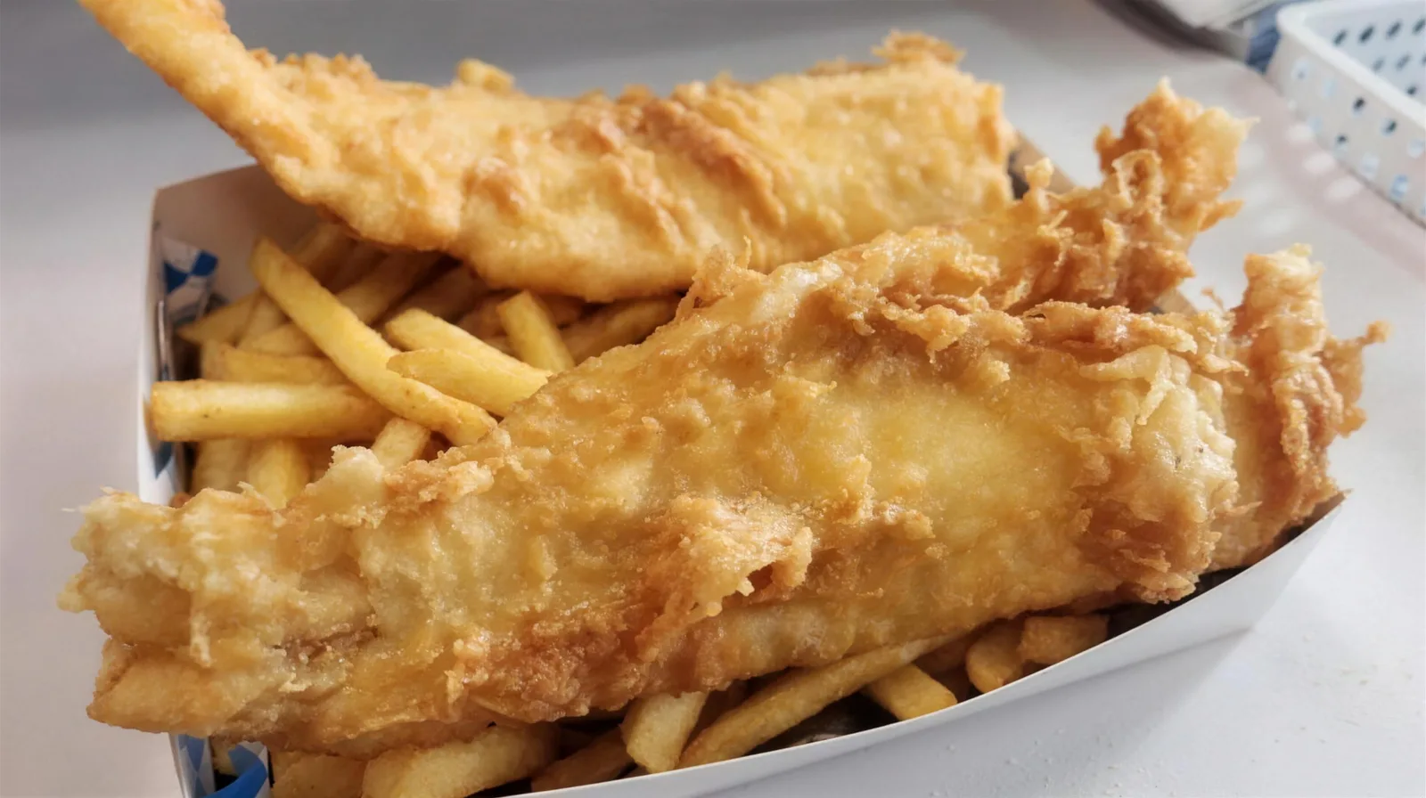 Two pieces of battered fish on chips